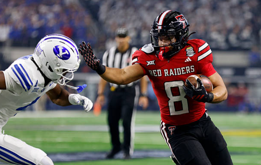 ARLINGTON, TEXAS - DECEMBER 6: Cameron Dickey #8 of the Texas Tech Red Raiders carries the ball as Mory Bamba #4 of the BYU Cougars pursues during the first half of the Big 12 Championship at AT&T Stadium on December 6, 2025 in Arlington, Texas. (Photo by Ron Jenkins/Getty Images)